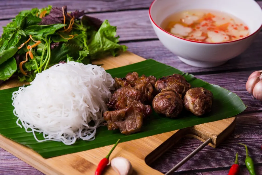 ハノイ風の盛り付け。ブン、炭火で焼いた豚肉、香草、ヌクチャムのタレ
